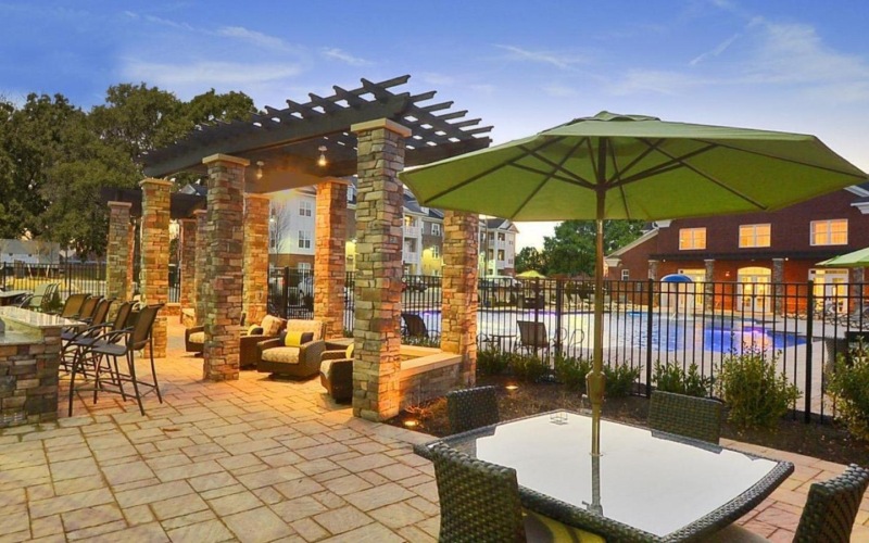 a patio with a pool and umbrella