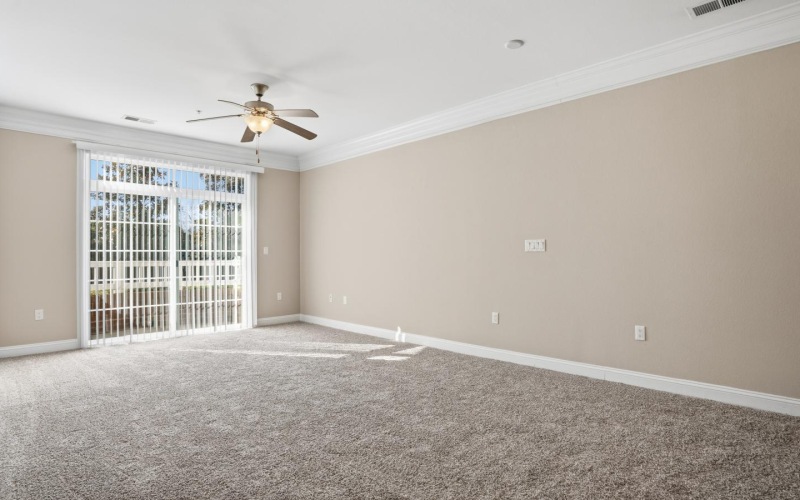 a room with a ceiling fan and a carpet