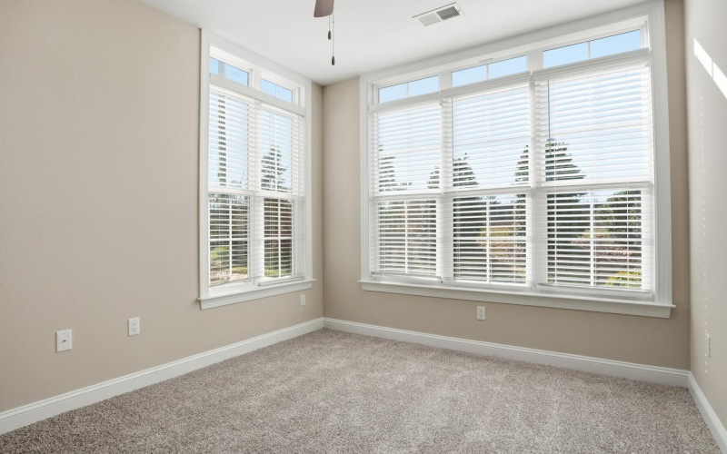 a room with a ceiling fan and a window with blinds